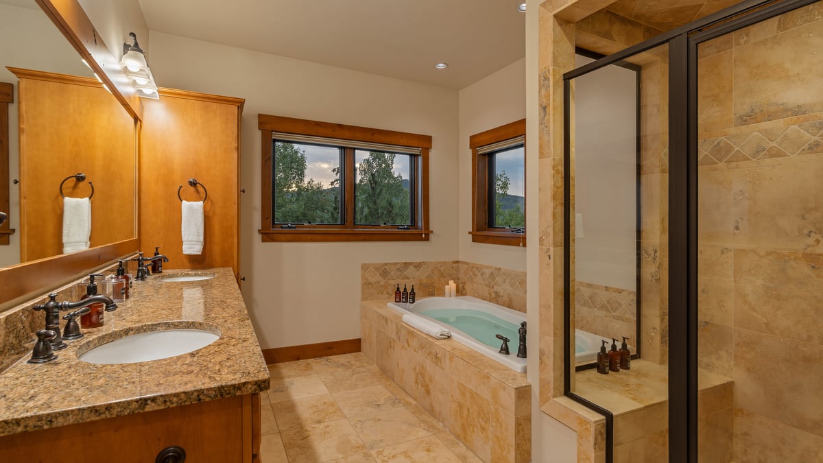 Primary ensuite on main level with tub, shower, and his/her sinks - Image 9