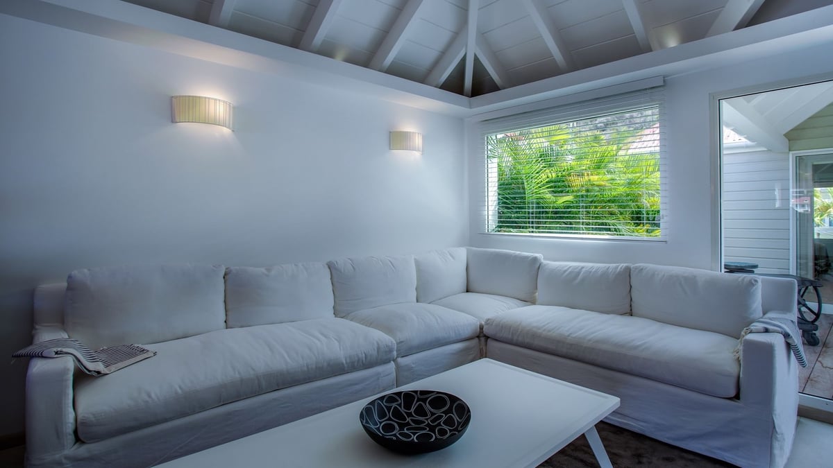 Living Area: Air-conditioned living room with a comfortable white sofa, a white table, and a flat sc - Image 12