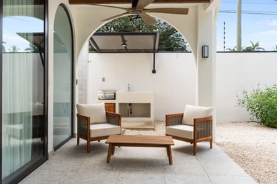 - Relax in this shaded lounge area with cushioned chairs and a wooden table
- Fire up the built in g