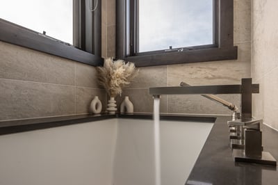 Your modern bathroom's sleek bronze fixtures and elegant stone tiles create a spa-like retreat where