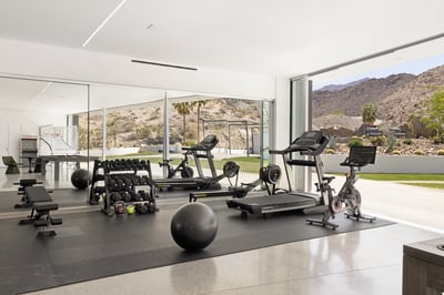 Gym area with weights, rower, treadmill and Peloton bike