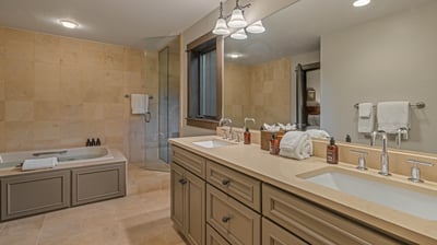 Twin bed ensuite with soaking tub, shower, and dual vanities