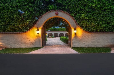 Grand Spanish-style archway welcomes guests through illuminated stucco walls framed by terracotta ti