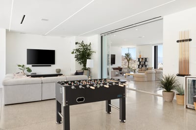 Game room features a billiards table, foosball, and basketball shooter game
