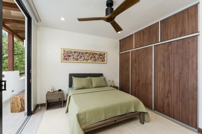 - Relax in a cozy room featuring earthy green bedding and rich wood closet panels
- Artistic touches