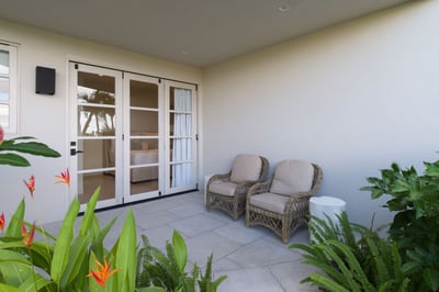 - Step into a private garden patio framed by tropical plants and soft light
- Rattan chairs offer th