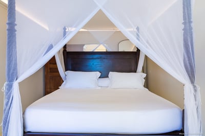 Bedroom 2: On the upper level. Air conditioning, ceiling fan, large black mahogany four-poster bed