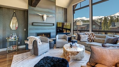 The great room features a gas fireplace, large flat screen TV and spectacular mountain views