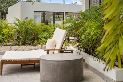 - Lounge in style on a cushioned recliner surrounded by tropical foliage
- Smooth concrete table add