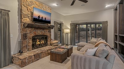 Sitting room of the guest apartment with wood fireplace, TV, and deck access; middle (3rd) level