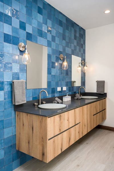 - Start your day at this striking blue tiled double vanity with vessel sinks
- Natural wood drawers 