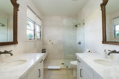 - Unwind in this bright bathroom with double vanities and carved antique mirrors
- Spacious glass sh