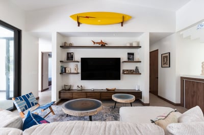 - Mounted TV framed by floating wood shelves & thoughtfully curated decor pieces
- Bold yellow surfb
