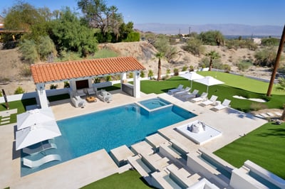 The second pool has dual waterfalls flowing into the saltwater pool with an oversize jacuzzi that se