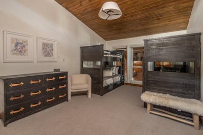 Your family will love this cozy bunk room with its rustic wood ceiling and modern furnishings for re
