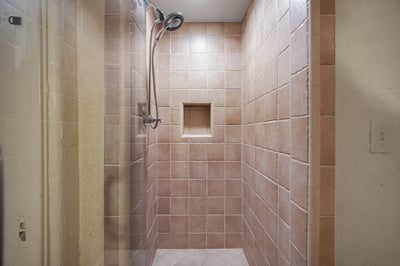 Step into your private tiled shower with dual showerheads and a built-in niche for your toiletries—e