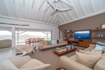 Living Area: Living room opening entirely onto the pool terrace, air conditioning, ceiling fans