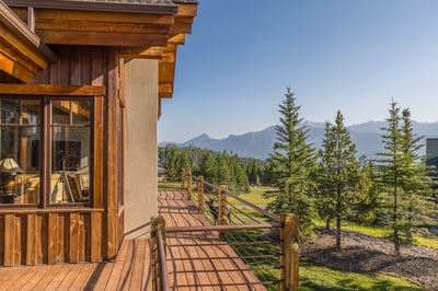 Stunning alpine retreat showcases dramatic mountain scenery framed by evergreen forests.