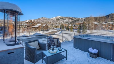 Hot tub on the deck in winter with mountain views