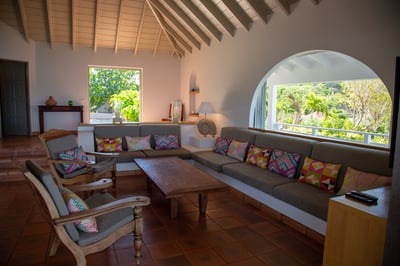 Living Area: Spacious living room with sliding glass doors, open onto the front and side terraces. T