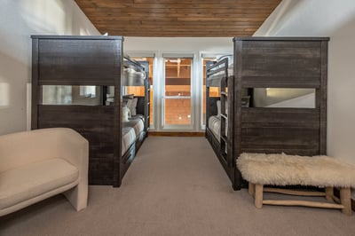 Your spacious bunk room features rustic wood bunks with plush linens and cozy seating for the perfec
