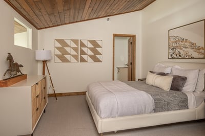 Drift off under stunning wood-planked ceilings in your stylish bedroom, where modern comfort meets m