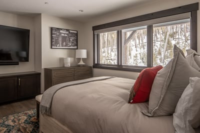 Wake up to stunning winter forest views from your cozy bedroom, where modern comfort meets mountain 