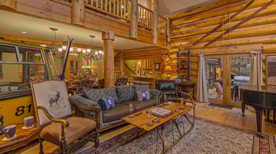 Open great room with gondola car, piano, and deck access