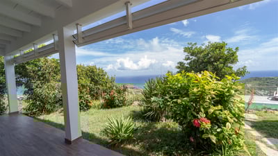 Outdoors: Lush tropical garden surrounding the property. Private parking at the entrance. 
