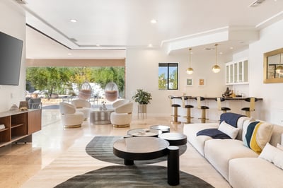 The main living space has an open concept with large floor to ceiling glass doors that disappear int