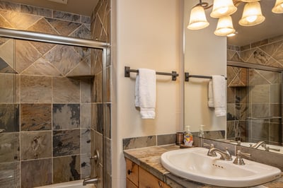 Your private bathroom features elegant marble tile work, plush towels, and warm lighting for your co