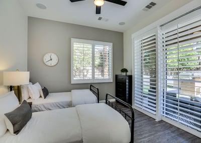 Guest bedroom 7 with two twin beds and direct access to the backyard