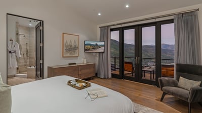Primary king suite on upper level with private heated balcony