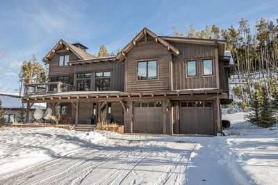 This stunning mountain lodge combines rustic charm with modern luxury, surrounded by snow-covered la