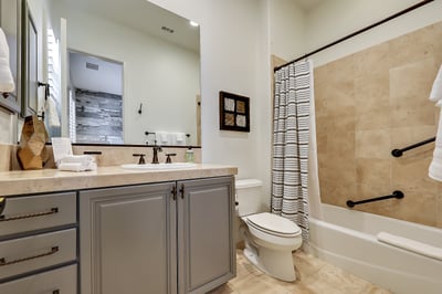 Guest bedroom 3 en suite with shower/tub combo and safety railing.