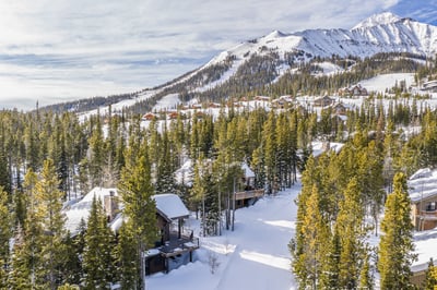 Mountain village nestled among snow-covered peaks and evergreen forests, showcasing pristine winter 