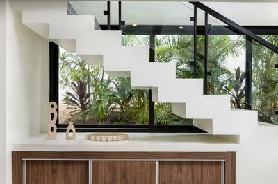 - Modern floating staircase framed by a beautiful garden through glass windows
- Clean architecture 
