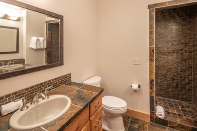 Your private bathroom features warm earth-tone tiles and a refreshing walk-in shower.
