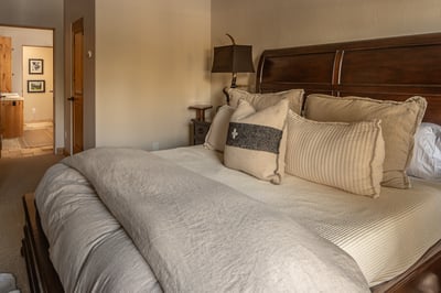 Sink into luxurious linens and plush pillows in your serene bedroom retreat, where warm wood tones c
