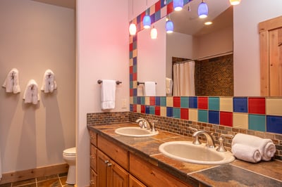 Double sinks and playful multicolored tile give you plenty of space to freshen up in style.