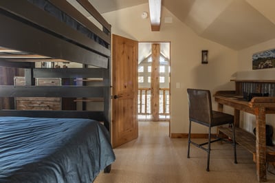 Your cozy loft bedroom features rustic wood beams and a convenient workspace, perfect for mountain r