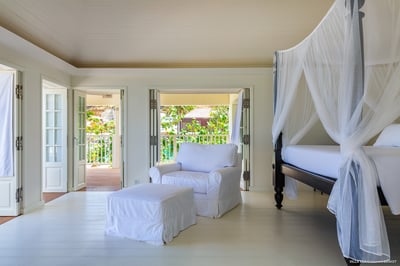 Bedroom 1: On the upper level. Air conditioning, ceiling fan, large black mahogany four-poster bed