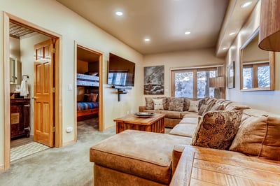 Lower family room with large couch and TV