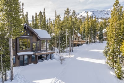 Mountain retreat nestled among snow-covered pines, with dramatic alpine peaks creating a stunning wi