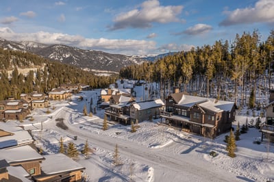 Snow-covered mountain community nestled among evergreen forests with stunning alpine peaks in the ba