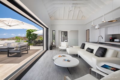 Living & Dining Area: Inside ocean view dining with a table for 6 guests and living with white sofas