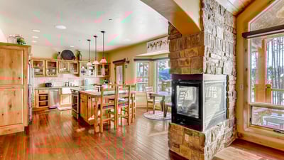 Two sided fireplace between kitchen and living area
