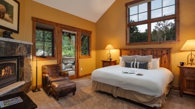 Primary bedroom on upper level with fireplace and deck access