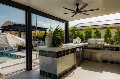 The outdoor kitchen, equipped with a barbecue, sink, and mini fridge