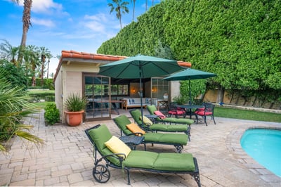 A private oasis awaits with lush lawn, shaded loungers, and poolside patio ideal for morning coffee 